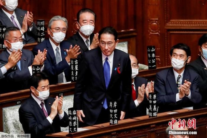 當?shù)貢r間10月4日，日本自民黨總裁岸田文雄經(jīng)過眾院全體會議的首相指名選舉成為第100任首相。圖為岸田文雄（中）起身致謝。