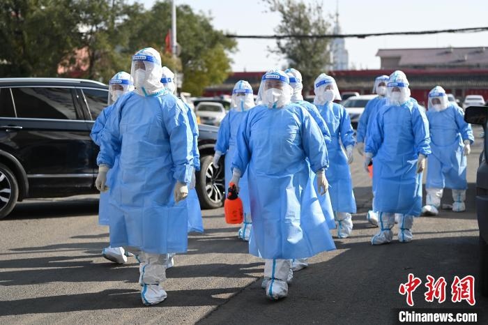 圖為醫(yī)務人員在封閉小區(qū)做防控工作?！⑽娜A 攝