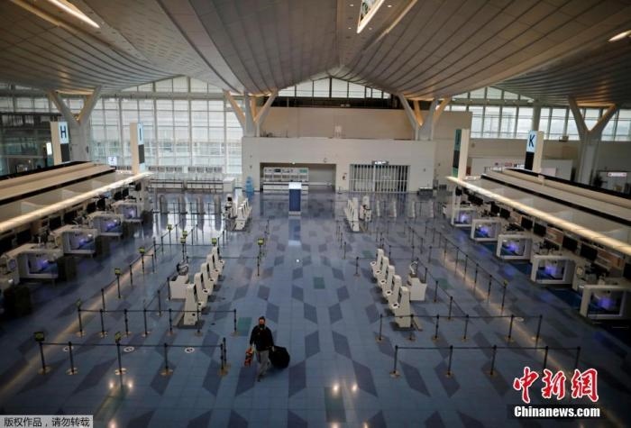 資料圖：日本東京，東京國(guó)際機(jī)場(chǎng)，一名乘客在國(guó)際航班航站樓的登機(jī)區(qū)。