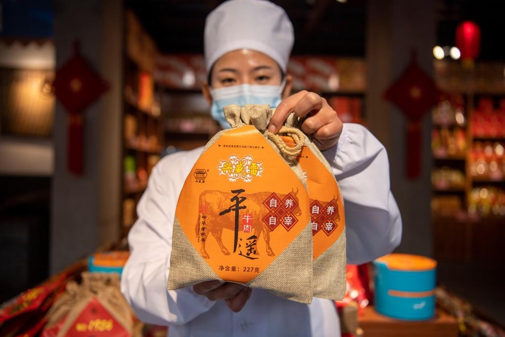 1月27日，在平遙古城南大街的一家平遙牛肉店內(nèi)，工作人員展示一款牛肉產(chǎn)品。新華社記者 楊晨光 攝