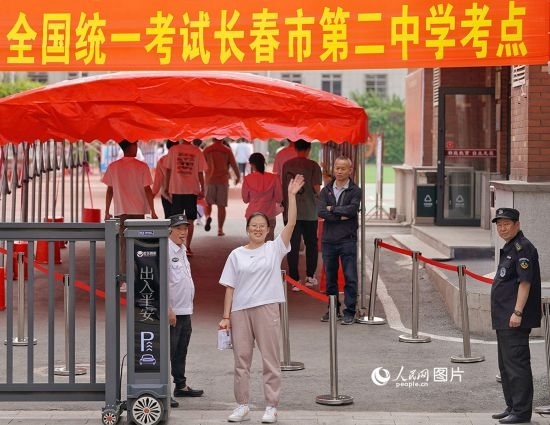 6月7日，在長(zhǎng)春市第二中學(xué)考點(diǎn)，一名考生信心滿滿進(jìn)入考場(chǎng)，并與家長(zhǎng)揮手致意。人民網(wǎng)記者 李洋攝