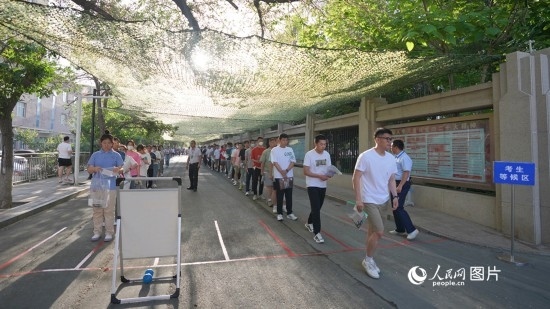 6月7日，烏魯木齊市第七十中學(xué)門口，考生們有序進(jìn)入考場(chǎng)。人民網(wǎng) 李欣洋攝