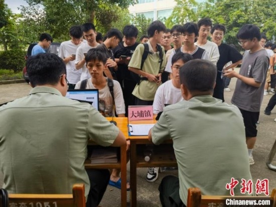 專武干部在發(fā)放兵役登記證。韋碩 攝