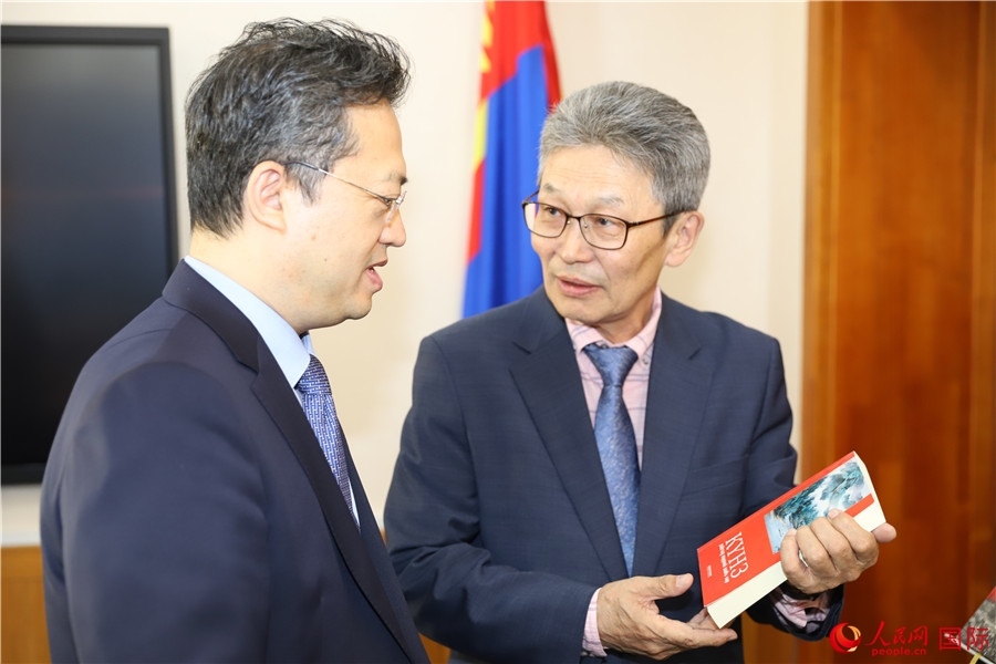 其米德策耶（右一）向李峙介紹翻譯成果。人民網(wǎng)記者 霍文攝