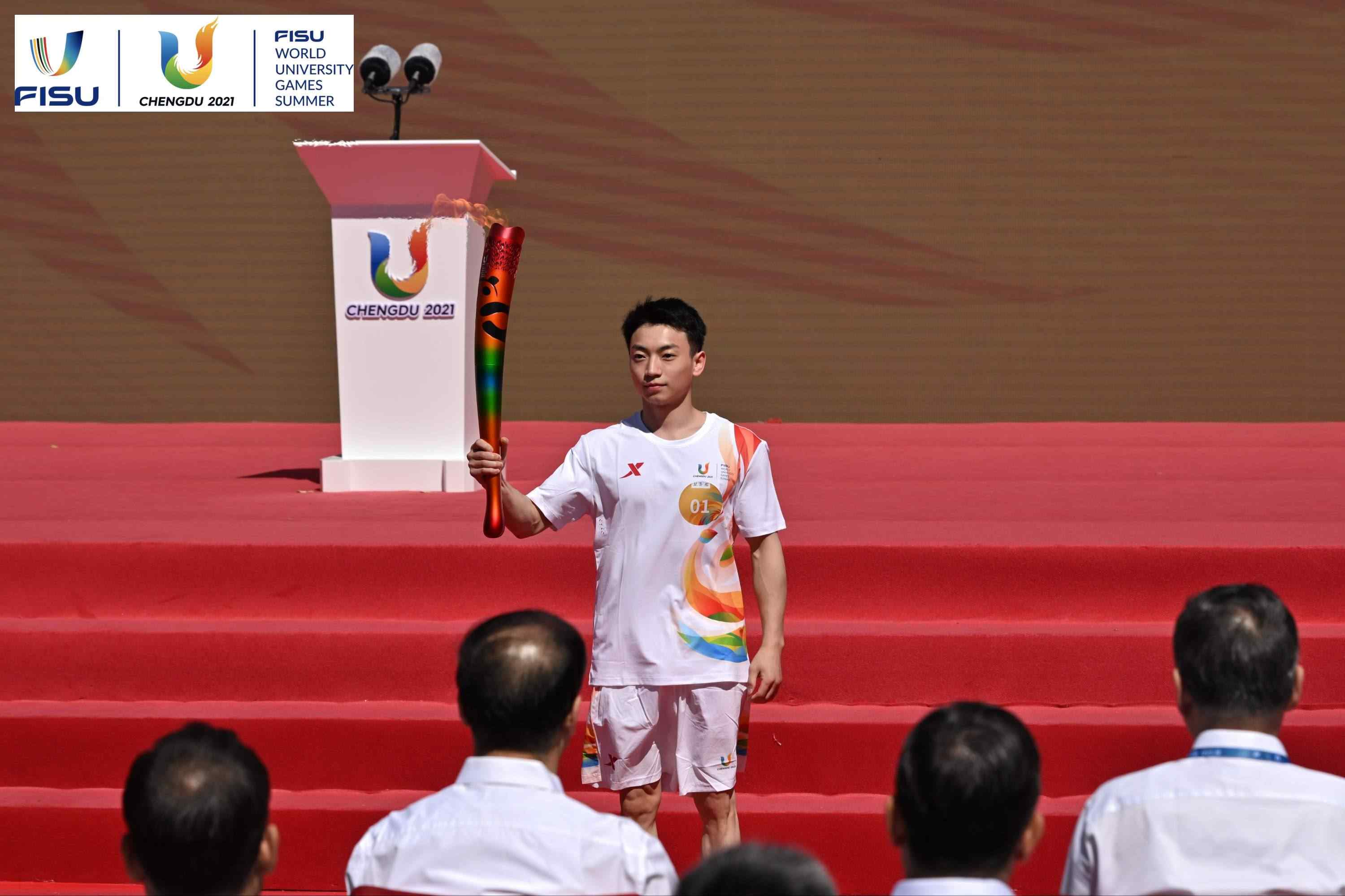 成都大運會火炬手、奧運冠軍鄒敬園高舉火炬。 圖片來源：成都大運會執(zhí)委會供圖