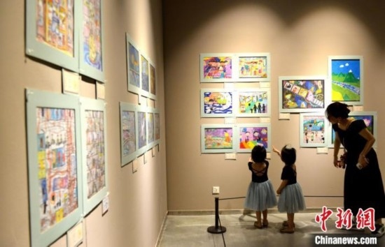 圖為家長(zhǎng)帶著孩子參觀展覽。呂明 攝