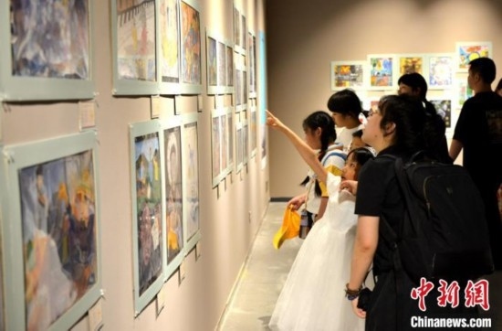 圖為家長(zhǎng)帶著孩子參觀展覽。呂明 攝