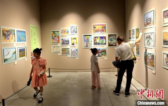 圖為家長(zhǎng)帶著孩子參觀展覽。呂明 攝