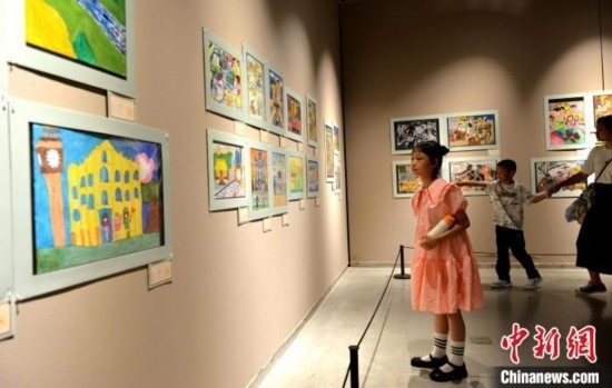 圖為家長(zhǎng)帶著孩子參觀展覽。呂明 攝