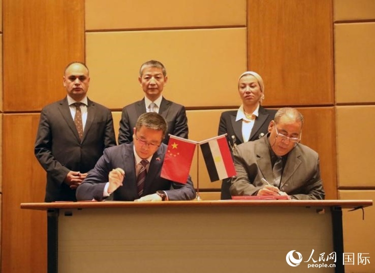 中國(guó)駐埃及使館公使張朝陽(yáng)與埃環(huán)境事務(wù)署工程和項(xiàng)目管理局局長(zhǎng)阿卜杜勒阿齊茲簽署交接證書(shū)。沈小曉攝