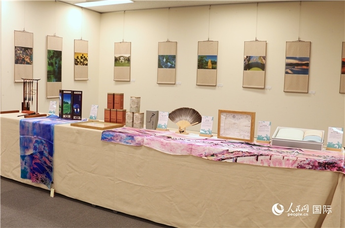 現(xiàn)場展出的馮學敏攝影作品與湖州市特色工藝品。（人民網(wǎng) 許可攝）