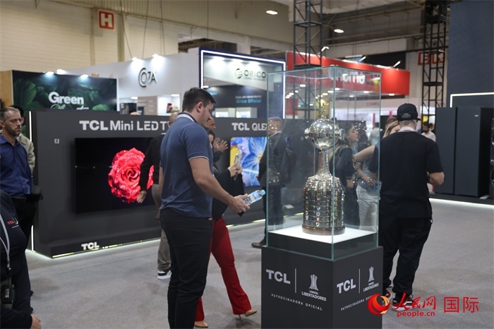 參觀者在TCL展臺前觀看南美解放者杯獎杯，據(jù)介紹，TCL是南美解放者杯（2023—2026賽季）全球官方合作伙伴。（人民網(wǎng)記者 時元皓攝）
