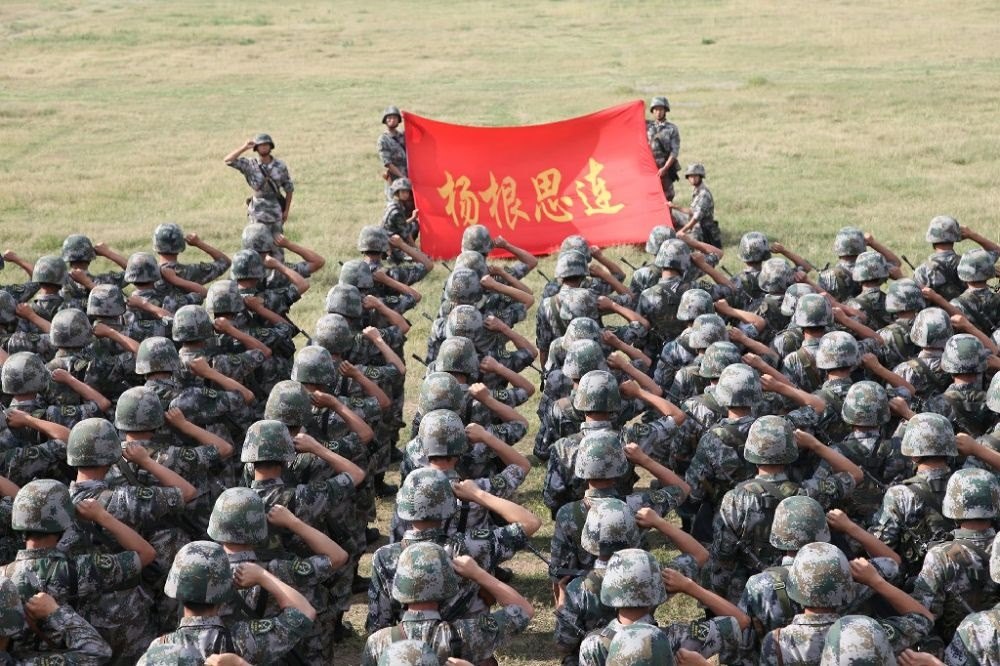 ↑“楊根思連”官兵執(zhí)行任務(wù)前向連旗宣誓（資料照片）。新華社發(fā)