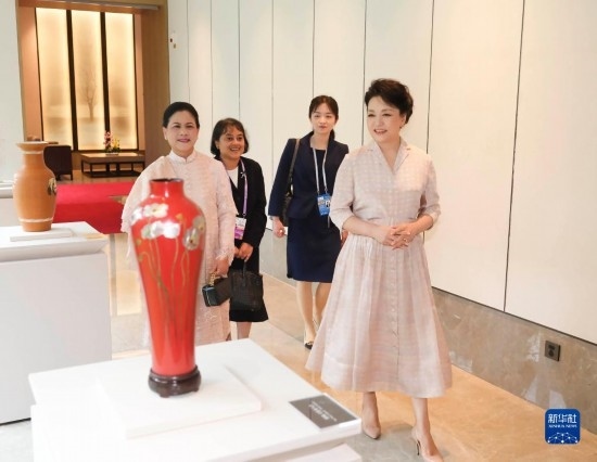 7月27日下午，國家主席習近平夫人彭麗媛在四川成都會見陪同印度尼西亞總統(tǒng)佐科來華出席第31屆世界大學生夏季運動會開幕式并訪華的總統(tǒng)夫人伊莉亞娜。這是彭麗媛和伊莉亞娜欣賞成都特色非遺工藝品。新華社記者 丁林 攝