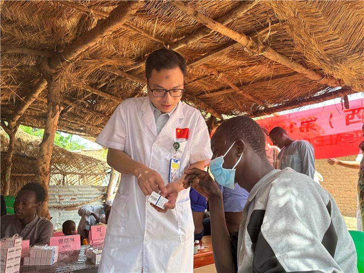 圖為南昌大學第一附屬醫(yī)院病理科主治醫(yī)師張振東為村民解說藥品使用方法。中國駐乍得醫(yī)療隊供圖
