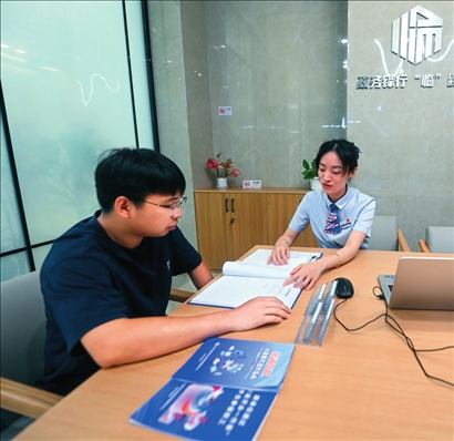 在杭州市臨安區(qū)政務(wù)服務(wù)中心的“為企服務(wù)中心”，黨員志愿者（右）解答企業(yè)主的疑問（2023年7月7日攝）。徐昱攝/本刊