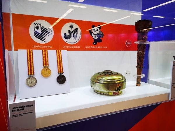1990年北京亞運(yùn)會獎牌、火種盒、火炬等展品。 人民網(wǎng)記者 楊磊攝