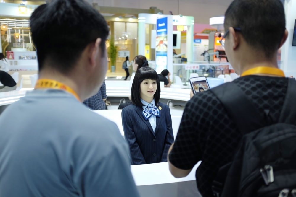 9月1日，媒體記者在國(guó)家會(huì)議中心與服務(wù)機(jī)器人互動(dòng)。新華社記者 劉夢(mèng)琪 攝