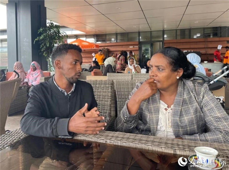 約漢斯（圖左）與德貝拉在友誼廣場咖啡廳交談。人民網(wǎng)記者 趙艷紅攝