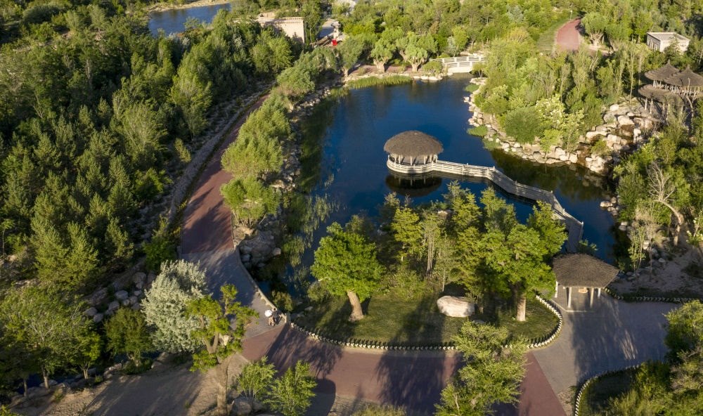 坐落在寧夏銀川市賀蘭山腳下的賀蘭山運(yùn)動(dòng)休閑公園（2021年5月27日攝，無(wú)人機(jī)照片）。這里曾是一片砂石采礦塌陷區(qū)，當(dāng)?shù)赝ㄟ^(guò)植被景觀再造、水系建設(shè)、現(xiàn)代管網(wǎng)鋪建等手段，重新利用廢石、廢坑及各類(lèi)廢棄建筑材料，把這里變成一座免費(fèi)開(kāi)放的主題公園。新華社記者 馮開(kāi)華 攝