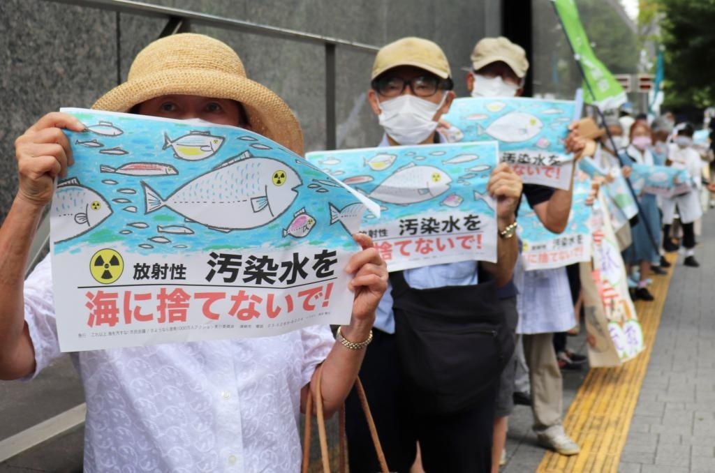 8月24日，日本民眾手持“不要將污染水扔進大?！钡葮苏Z在東京電力公司總部前集會，抗議日本政府和東電公司無視民意啟動核污染水排海。新華社記者楊光攝