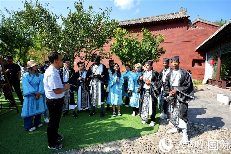 圖為選手們聽導游講解。人民網 盧鵬宇攝