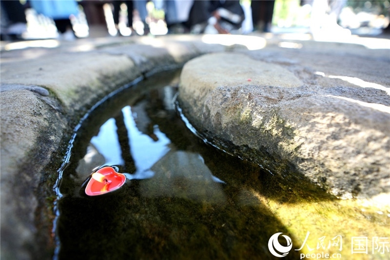 圖為水渠里流過的“桃心”蠟燭。人民網 盧鵬宇攝