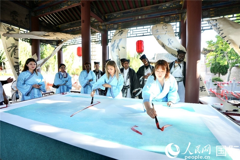 選手們提筆書寫“家園”二字。人民網 盧鵬宇攝