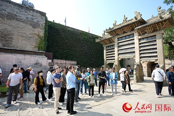 選手們認(rèn)真聆聽導(dǎo)游講解。人民網(wǎng) 盧鵬宇攝