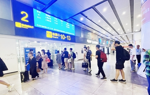 在快速進(jìn)站廳前排隊等待檢票的旅客。人民網(wǎng)記者 喬雪峰攝