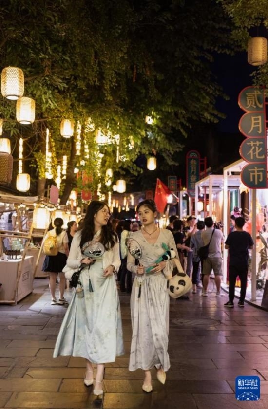 在成都寬窄巷子，兩位來(lái)自安徽的游客在新“十二月市”街區(qū)游覽（9月29日攝）。