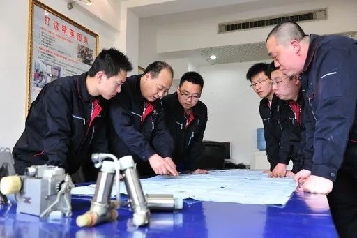 △李志強(qiáng)（左二）與班組成員在研究工作。