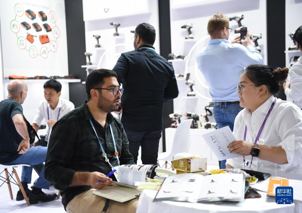 10月15日，在一家電動工具展臺，外國采購商在洽談業(yè)務(wù)。新華社記者 鄧華 攝