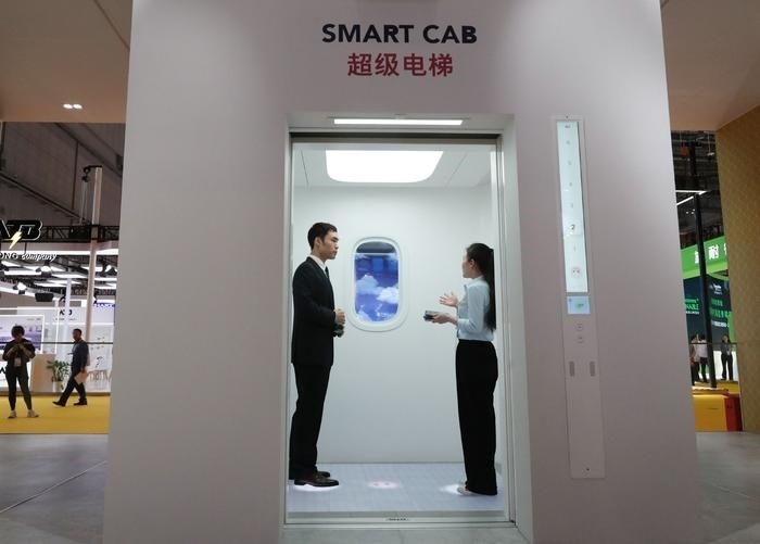 11月5日，工作人員（右）在第六屆進(jìn)博會(huì)上向參觀者介紹奧的斯公司全新推出的超級(jí)電梯。