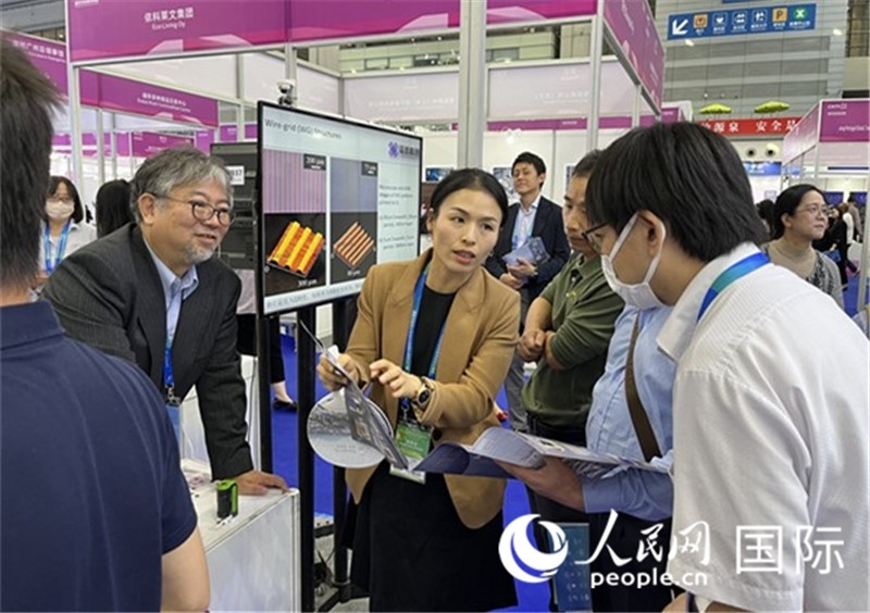 工作人員向參觀者介紹超級噴墨技術(shù)。（人民網(wǎng)記者 陳思攝）