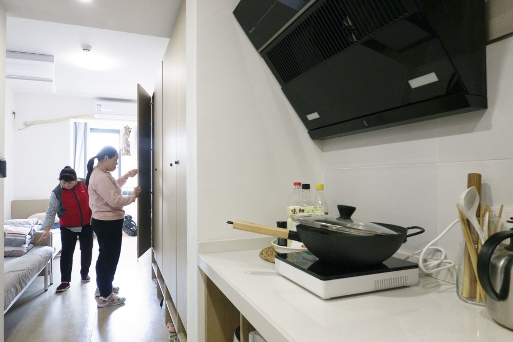 住戶在閔行區(qū)新時代城市建設者管理者之家收拾房間。