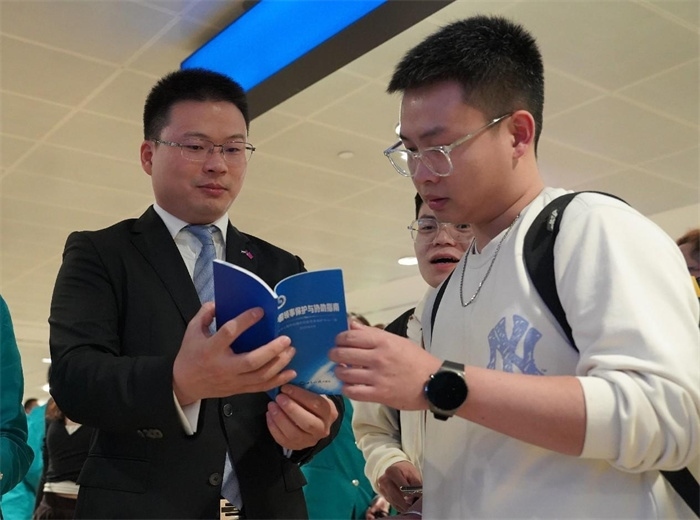 工作人員（左一）在發(fā)放《中國領(lǐng)事保護(hù)與協(xié)助指南》。 中國駐迪拜總領(lǐng)事館供圖