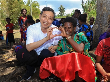 2023年12月18日，中國駐瓦努阿圖大使李名剛和前來觀看瓦努阿圖公路項(xiàng)目二期馬勒庫拉段移交儀式的當(dāng)?shù)鼐用窈嫌?。人民網(wǎng) 賀吉攝