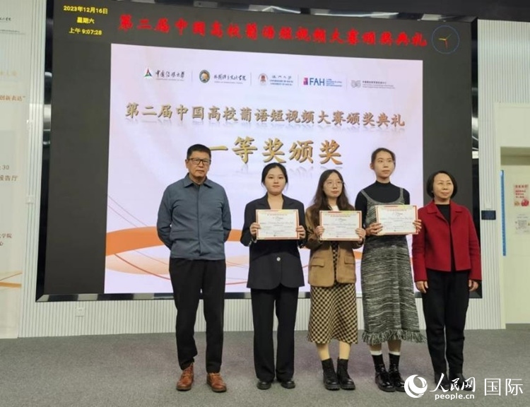 澳門大學中葡雙語教學暨培訓中心主任姚京明（左一）和中國傳媒大學外國語言文化學院院長文春英（右一）為一等獎獲得者頒獎。人民網(wǎng)記者 魯揚攝