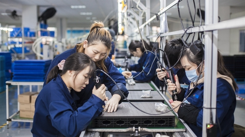 在新亞勝光電的產(chǎn)品線上，工人正進(jìn)行產(chǎn)品組建和安裝布線。受訪者供圖
