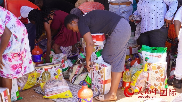 當?shù)厣鐓^(qū)家庭領(lǐng)取物資。人民網(wǎng) 張茜攝