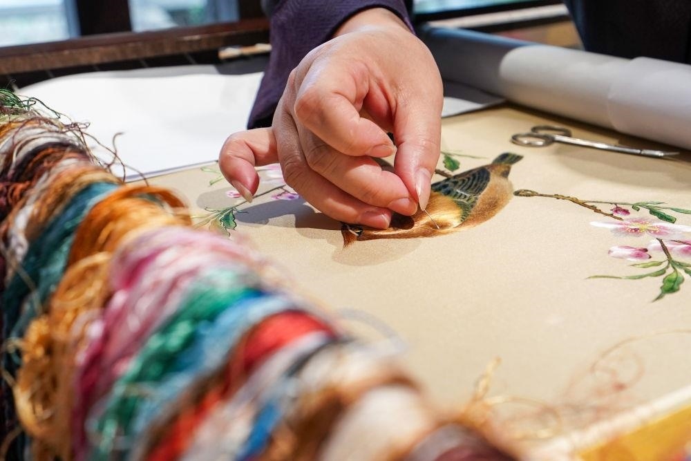 △2023年7月6日，盧建英在江蘇蘇州平江路的工作室內(nèi)刺繡。