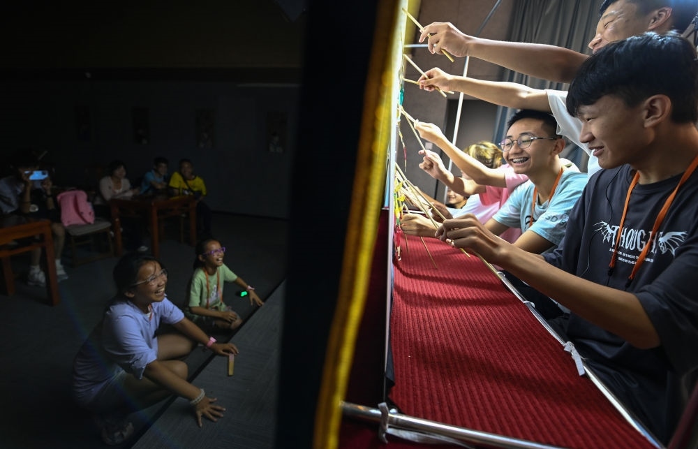 2023年8月8日，進行暑期研學(xué)的學(xué)生在位于陜西省西安市的中國秦腔藝術(shù)博物館體驗皮影戲演出。新華社記者 鄒競一 攝