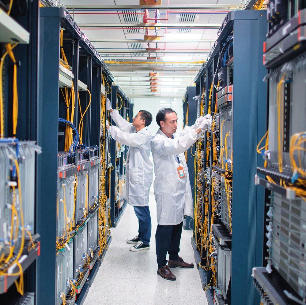 在位于武漢中國(guó)光谷的光電器件研發(fā)制造商——武漢光迅科技股份有限公司生產(chǎn)車(chē)間內(nèi)，技術(shù)人員在光模塊生產(chǎn)線作業(yè)（2023年4月11日攝）。程敏攝/本刊