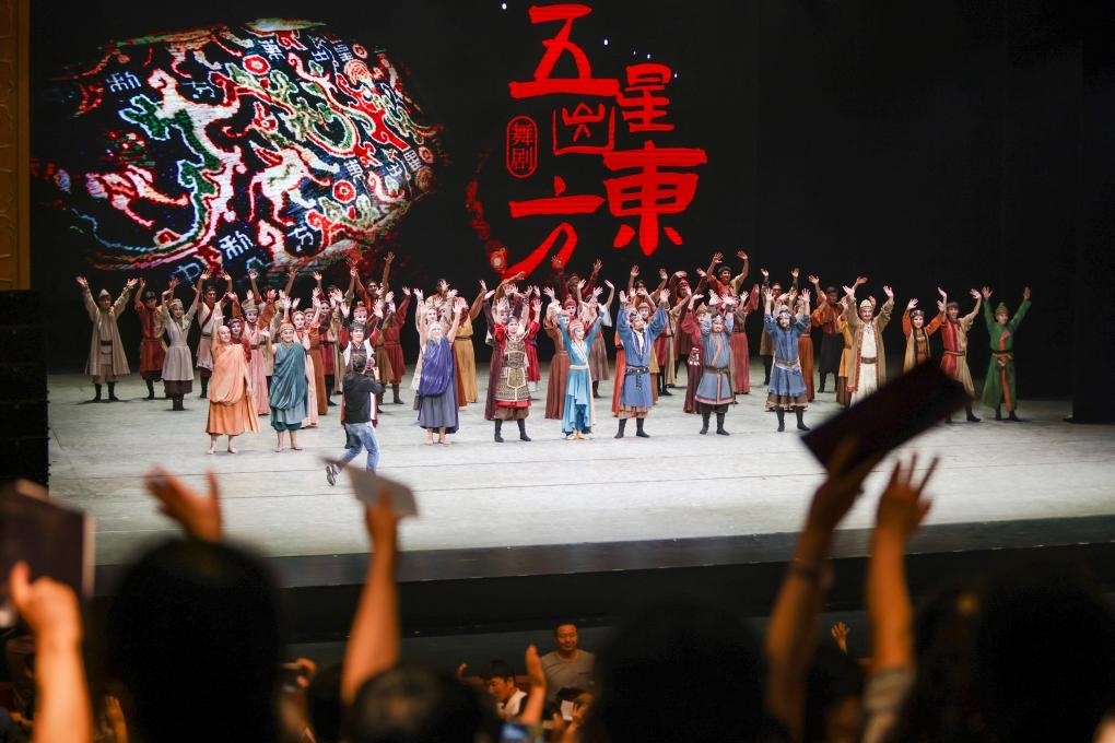 2023年7月31日，新疆和田地區(qū)新玉歌舞團在烏魯木齊京劇院演出舞劇《五星出東方》后和觀眾互相揮手致意。這場演出是第六屆中國新疆國際民族舞蹈節(jié)的參演劇目之一，曾榮獲國家“文華獎”等。新華社記者 郝昭 攝