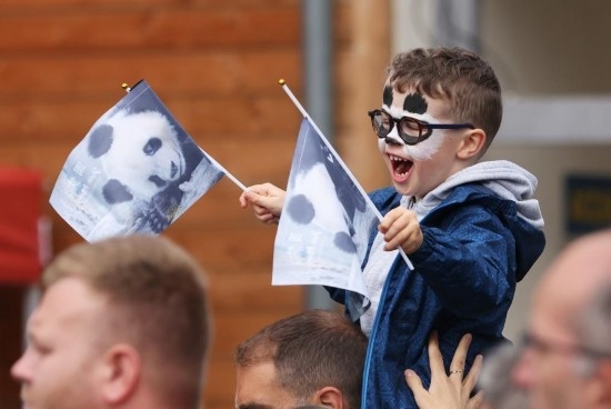  2023年7月26日，在法國(guó)圣艾尼昂市博瓦勒野生動(dòng)物園外，一名兒童等待送別熊貓“圓夢(mèng)”。新華社記者 高靜 攝