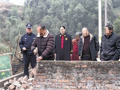  圖③：庭審結(jié)束后，在法官的見證下，陳某在院壩邊重新開鑿一條通道。