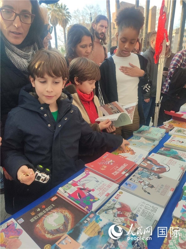 印刷精美的中國(guó)傳統(tǒng)文化叢書(shū)吸引了小游客的注意。人民網(wǎng)記者鄭彬攝