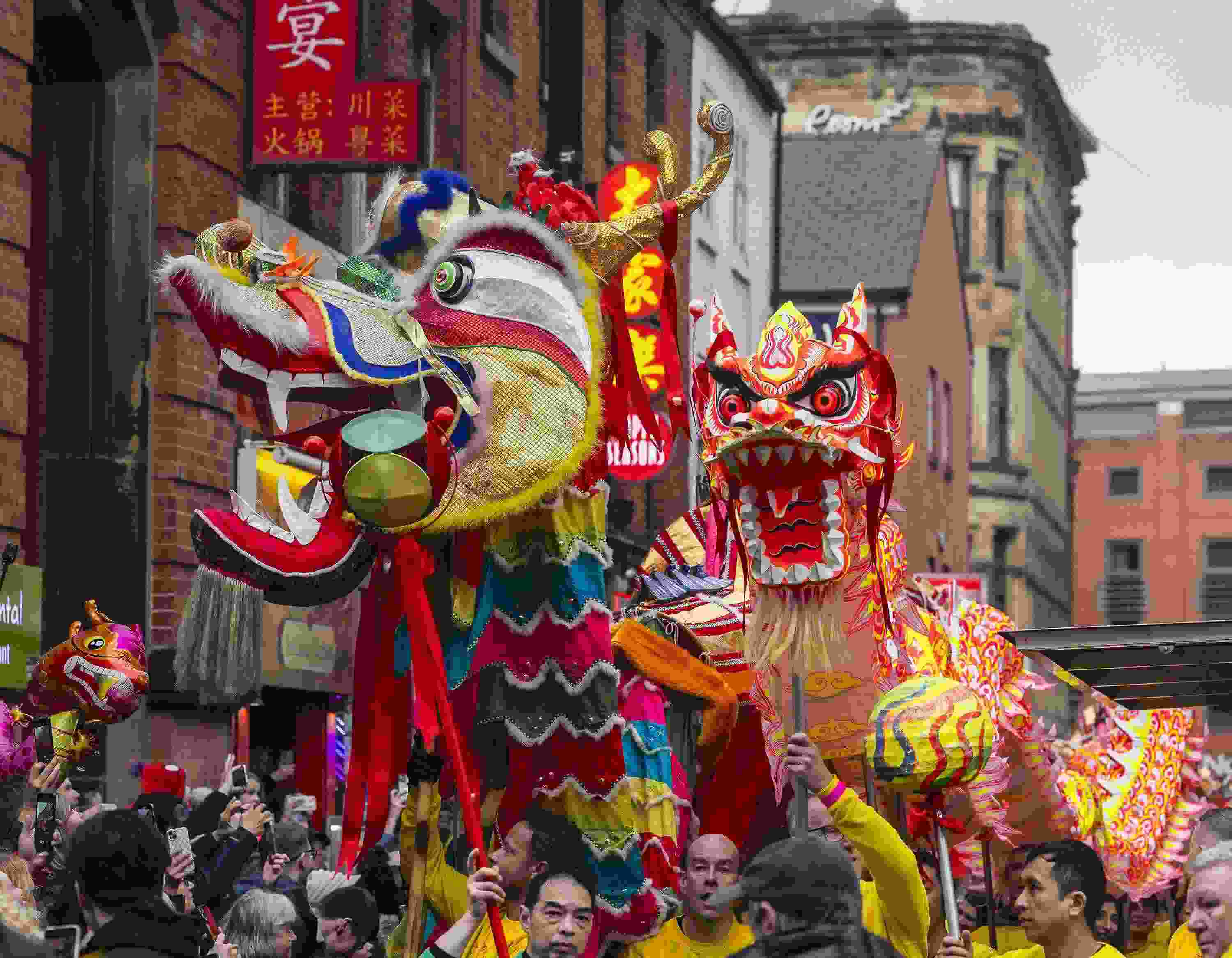 △ 當?shù)貢r間2024年2月11日，英國曼徹斯特，表演者進入中國城，參加中國農(nóng)歷龍年春節(jié)的慶?；顒印? width=