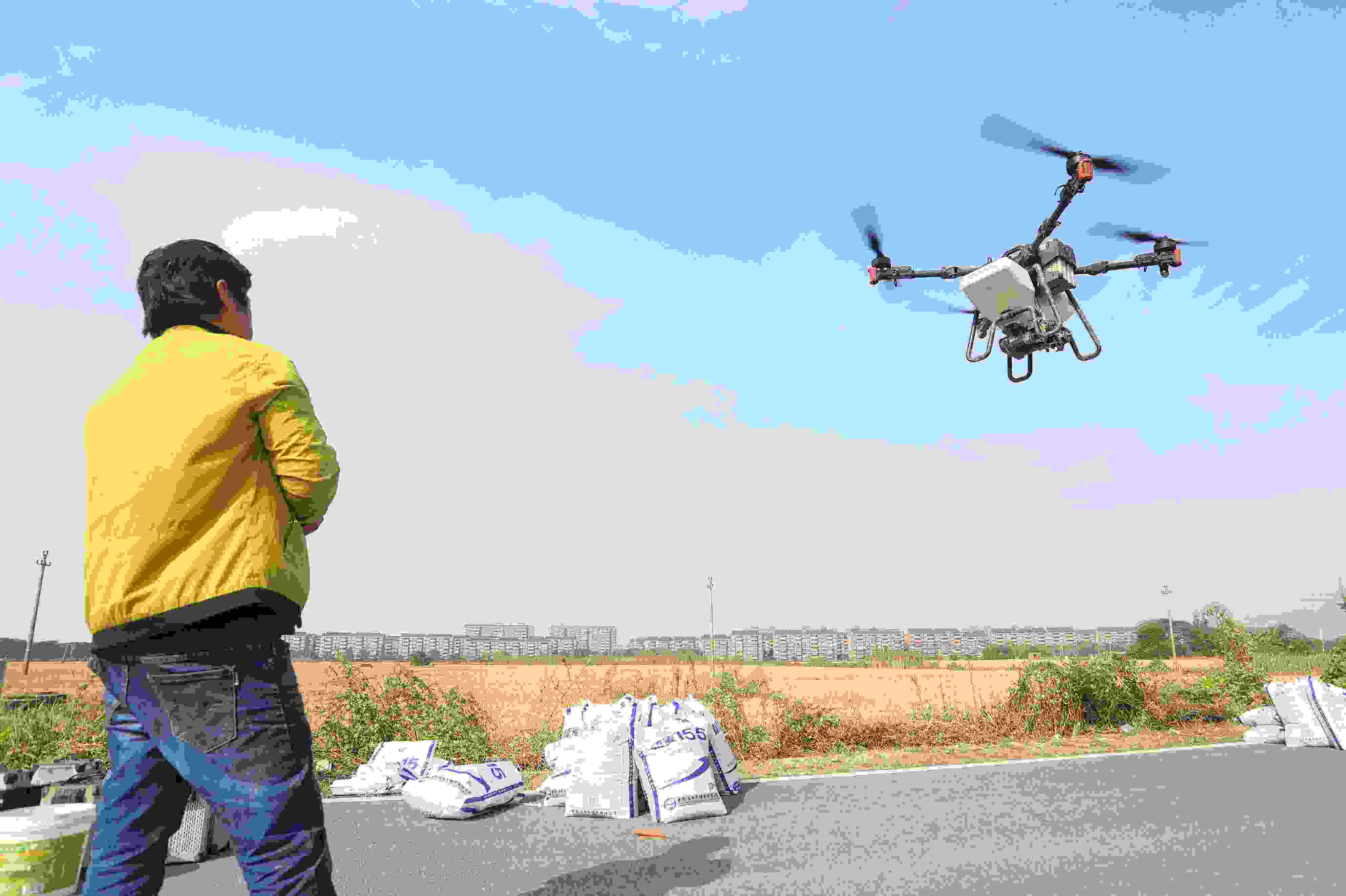 2023年11月15日，浙江嘉興，南湖區(qū)七星街道一處農(nóng)田里，農(nóng)民操縱無人機(jī)進(jìn)行冬小麥飛播。